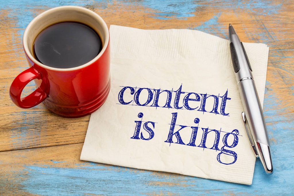 coffee cup on desk with Content is King paper under it