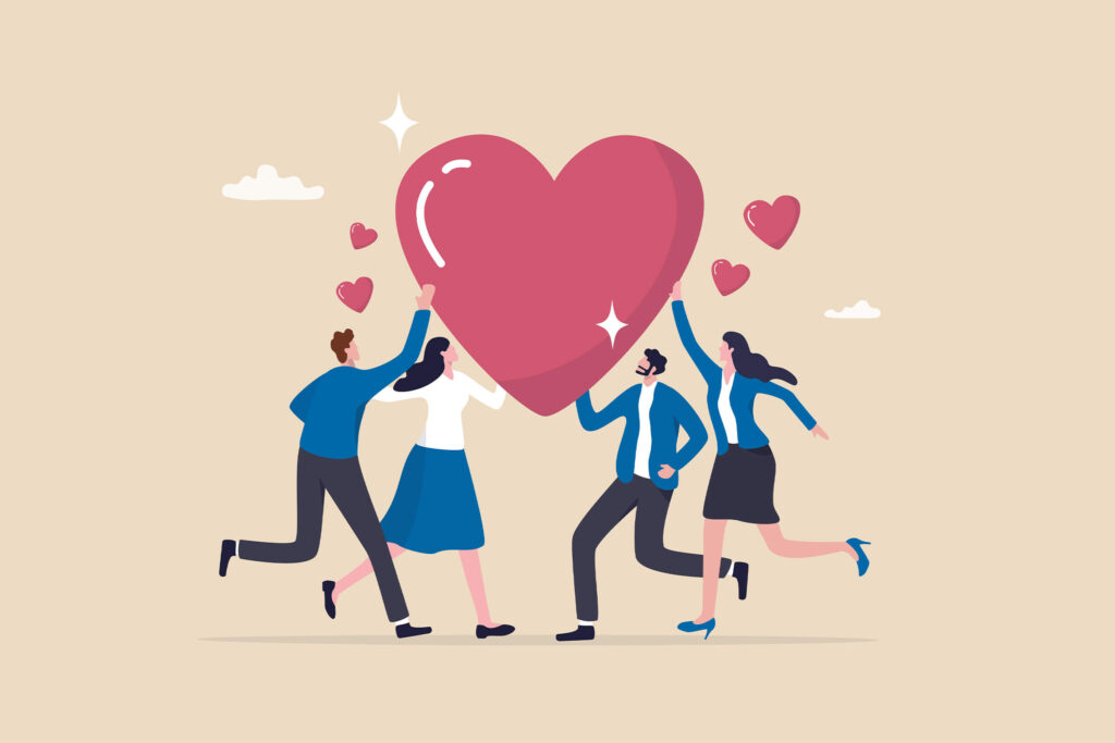 This image shows four businesspersons touching a heart to reflect teamwork and kindness.