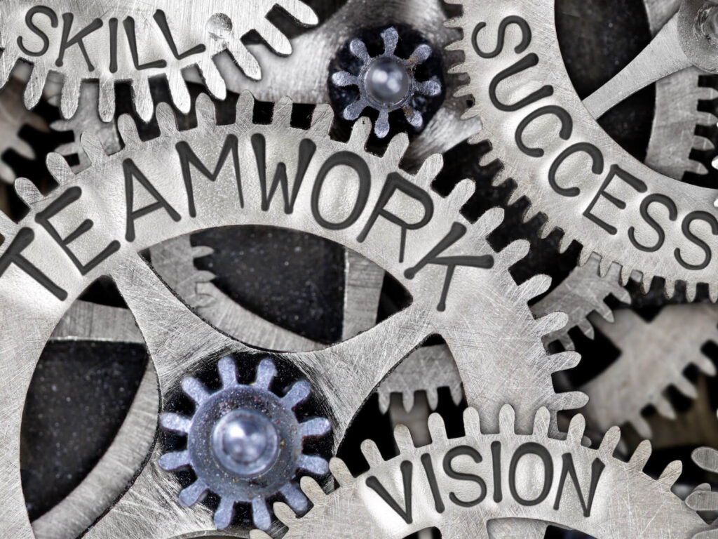 a set of interlocking gears with the different words written on each one, such teamwork, vision, success, and skill
